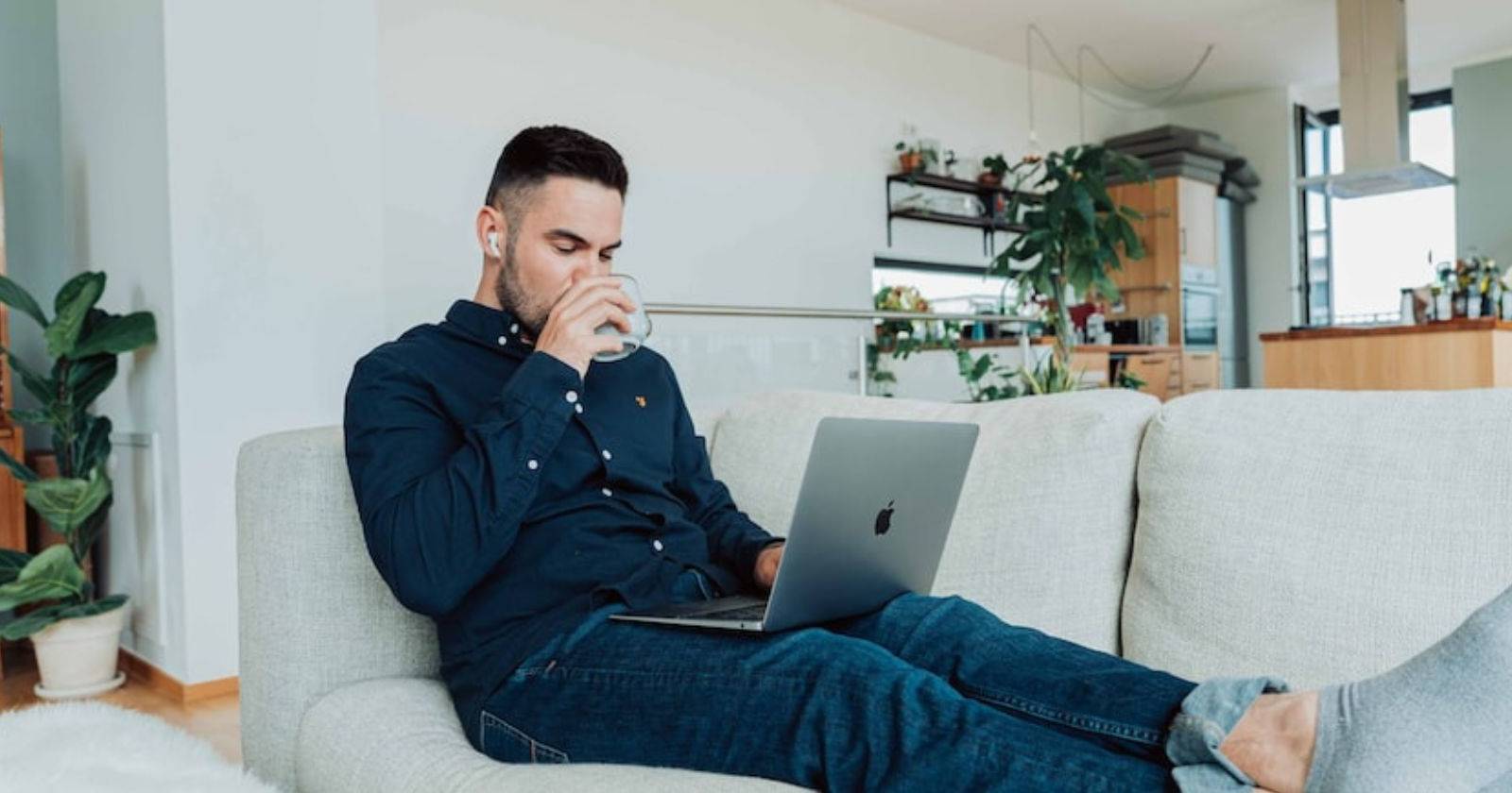 Мужчина пьёт кофе за ноутбуком, работает