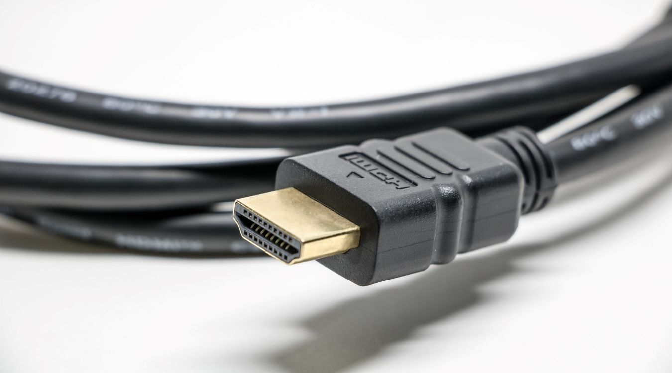 A photograph fo a standard HDMI cable atop a white surface