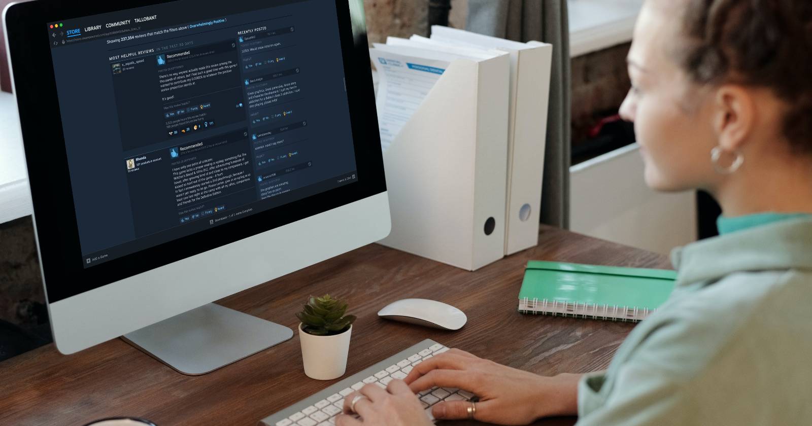 Женщина использует iMac, на экране видны отзывы Steam