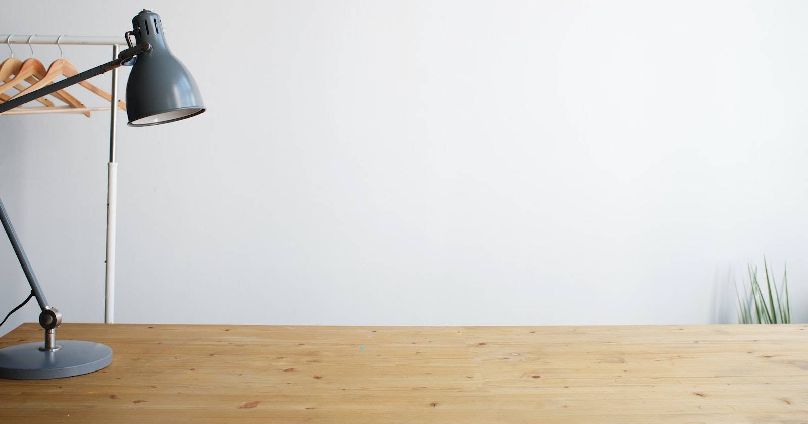 Большой деревянный стол с одной настольной лампой в углу