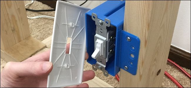 Выключатель частично вытащен из подрозетника, видны провода