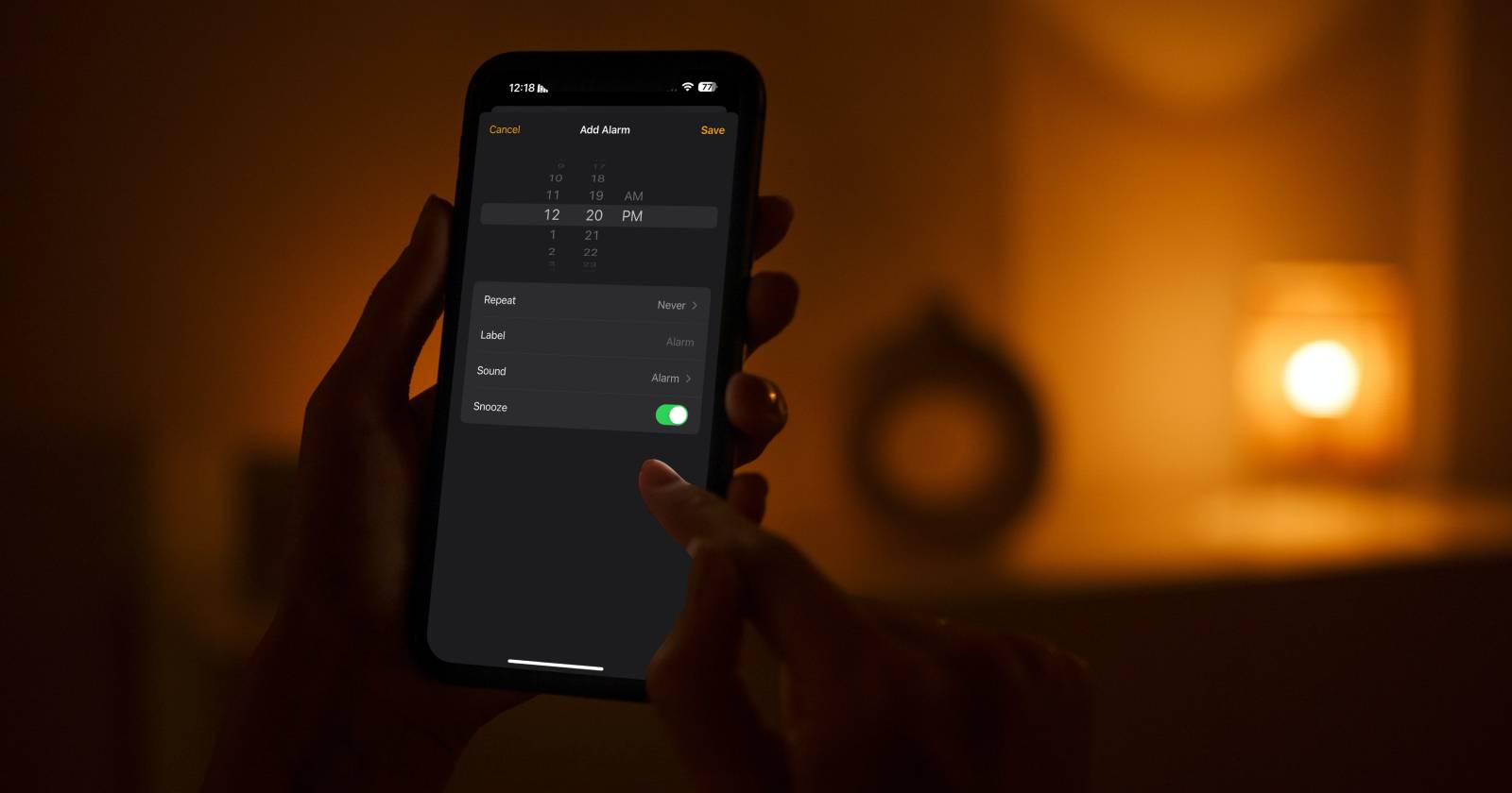 человек устанавливает будильник на iPhone