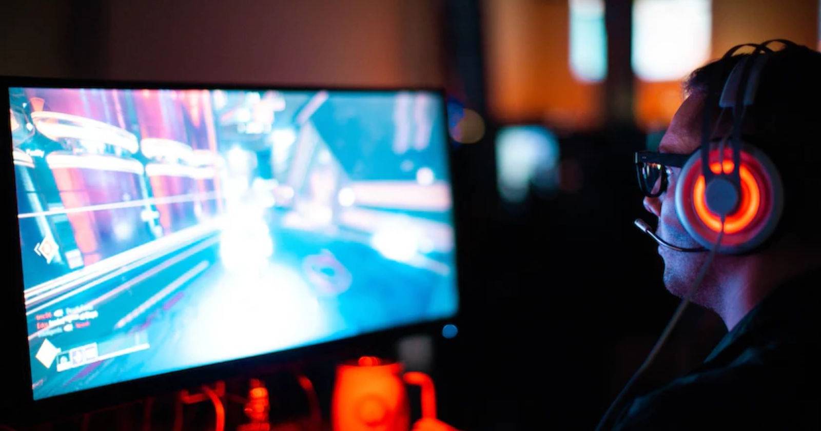 Мальчик играет в компьютерную игру с наушниками и контроллером