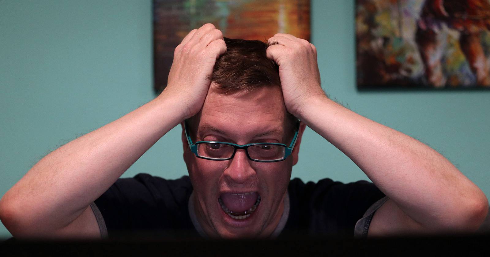 Мужчина в ужасе смотрит на экран компьютера