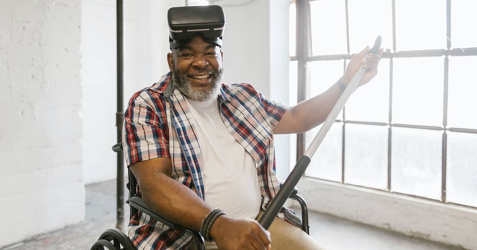 Мужчина в инвалидной коляске использует VR-гарнитуру