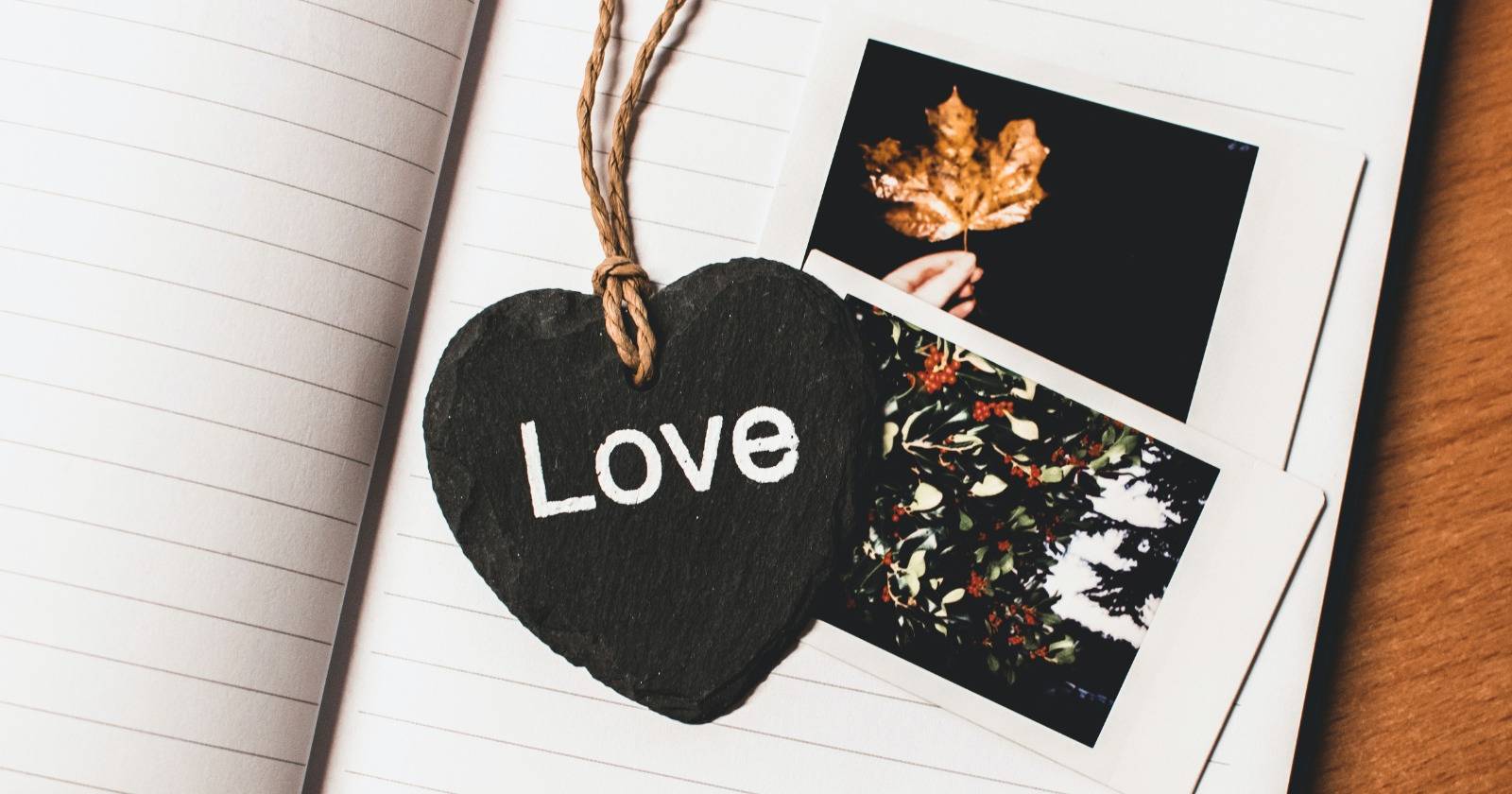 Закладка в форме сердца с надписью «Love» на двух полароидах в раскрытой книге