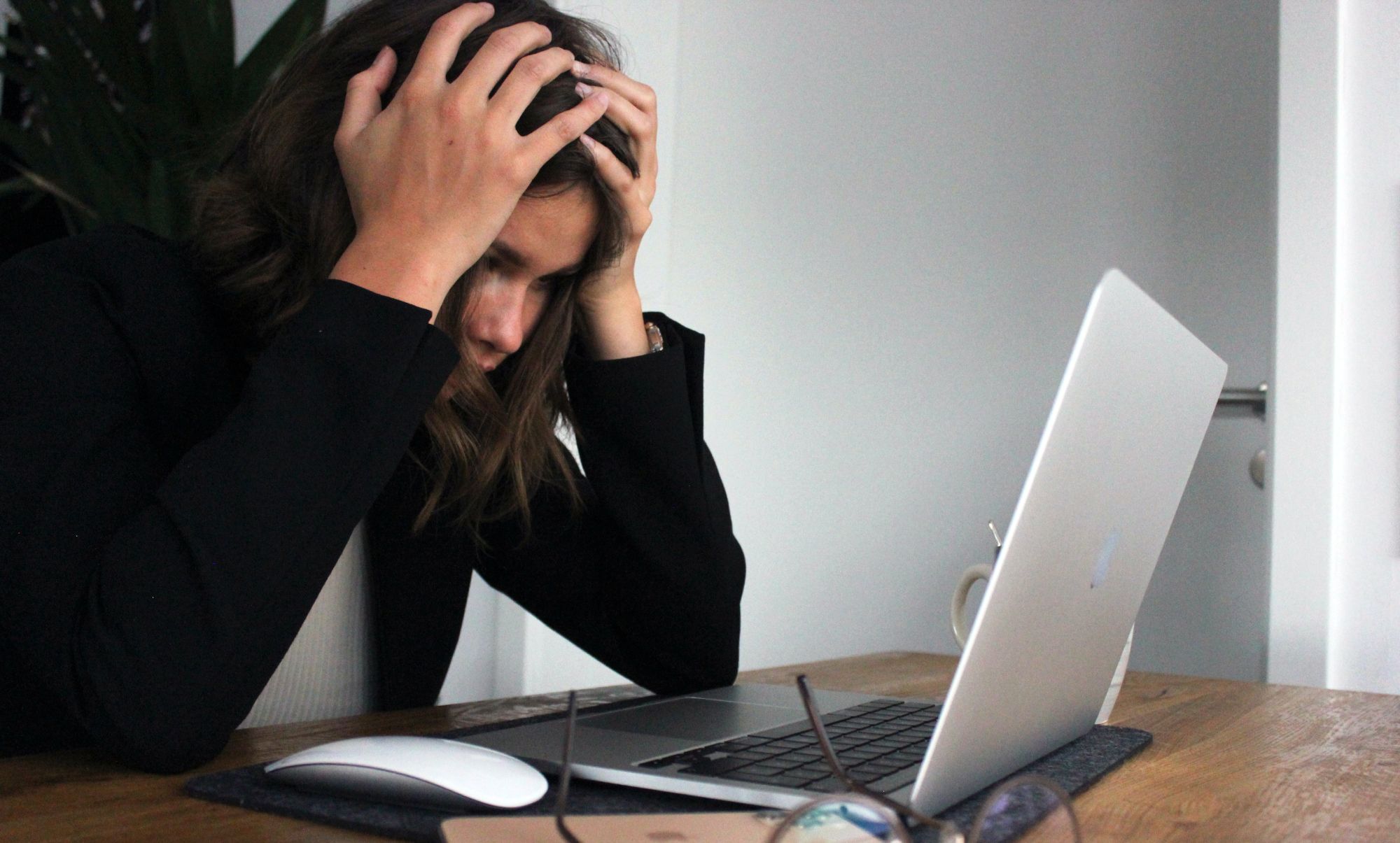 Женщина в стрессе смотрит на Mac