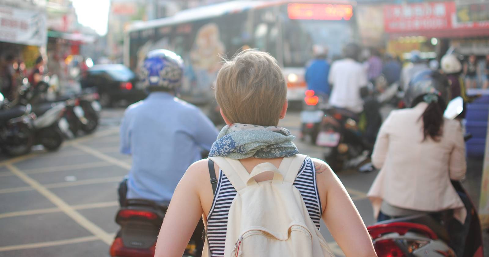 женщина идёт по оживлённой улице в сумерках