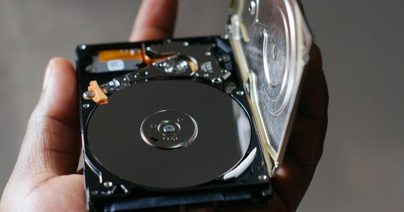 мужчина держит повреждённый жёсткий диск в руке