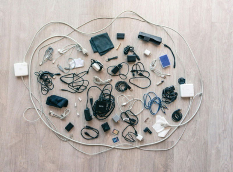 Mess of cables and chargers on a table.