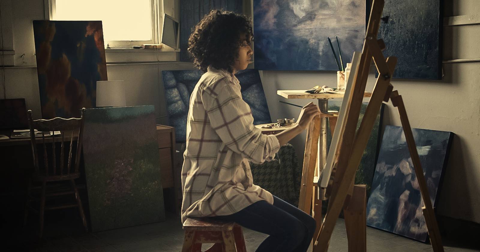 Женщина рисует на холсте