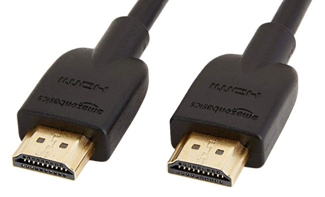 Кабель HDMI Amazon Basics рядом с ноутбуком и монитором.