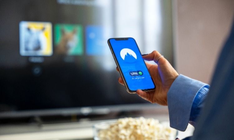 женщина держит телефон с показом подключения VPN
