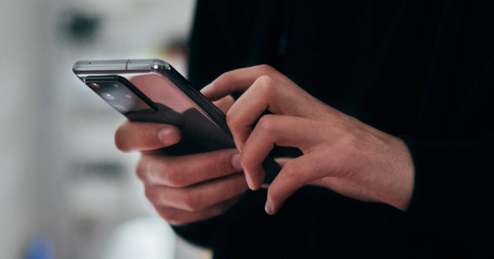 Руки держат смартфон и листают Instagram