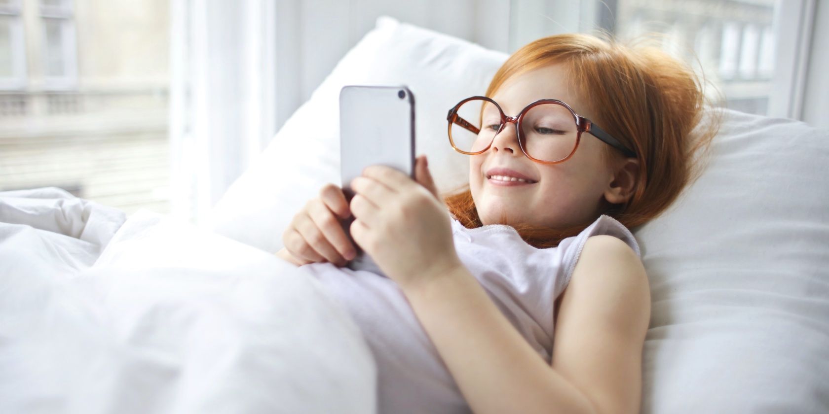 подросток смотрит на iPhone в кровати